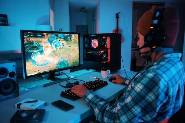 Hinweise auf Input Lag erkennen – Spieler am PC mit Headset und Game Gamer analysiert verzögertes Spielerlebnis am PC mit möglichem Input Lag