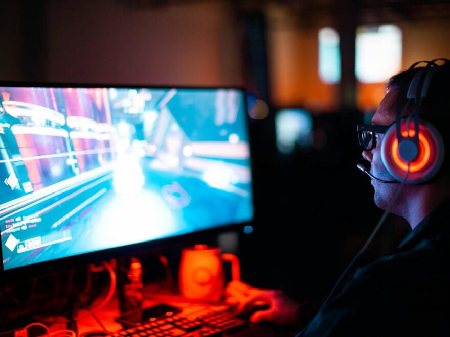 Gamer am PC mit Headset, der ein Spiel mit möglichem Input Lag erlebt