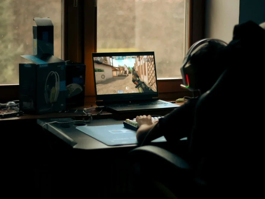 Gamer spielt Shooter am PC, Bilddarstellung auf dem Monitor wirkt unsauber und nicht synchron